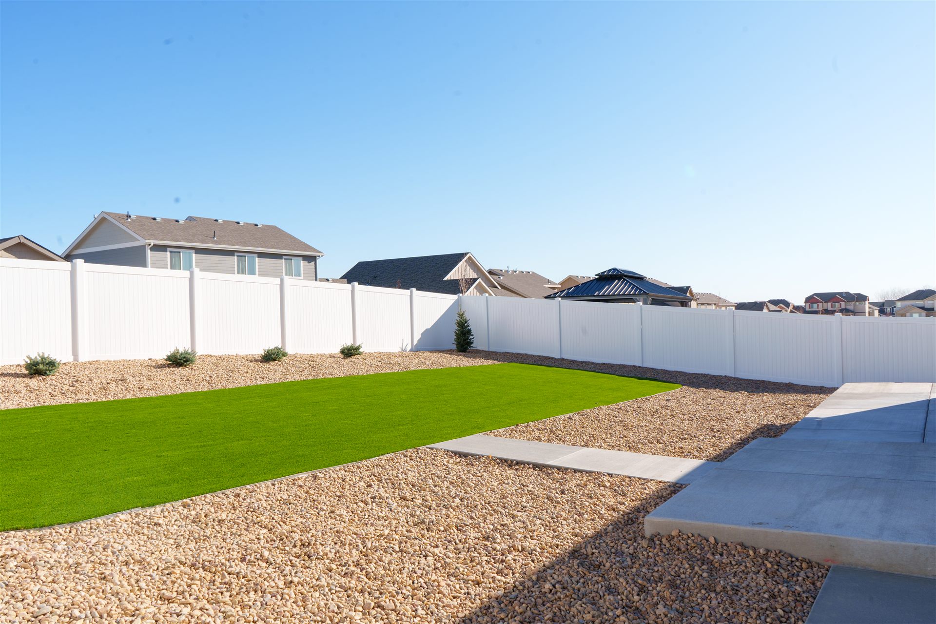 Concrete walkway beside a synthetic turf lawn