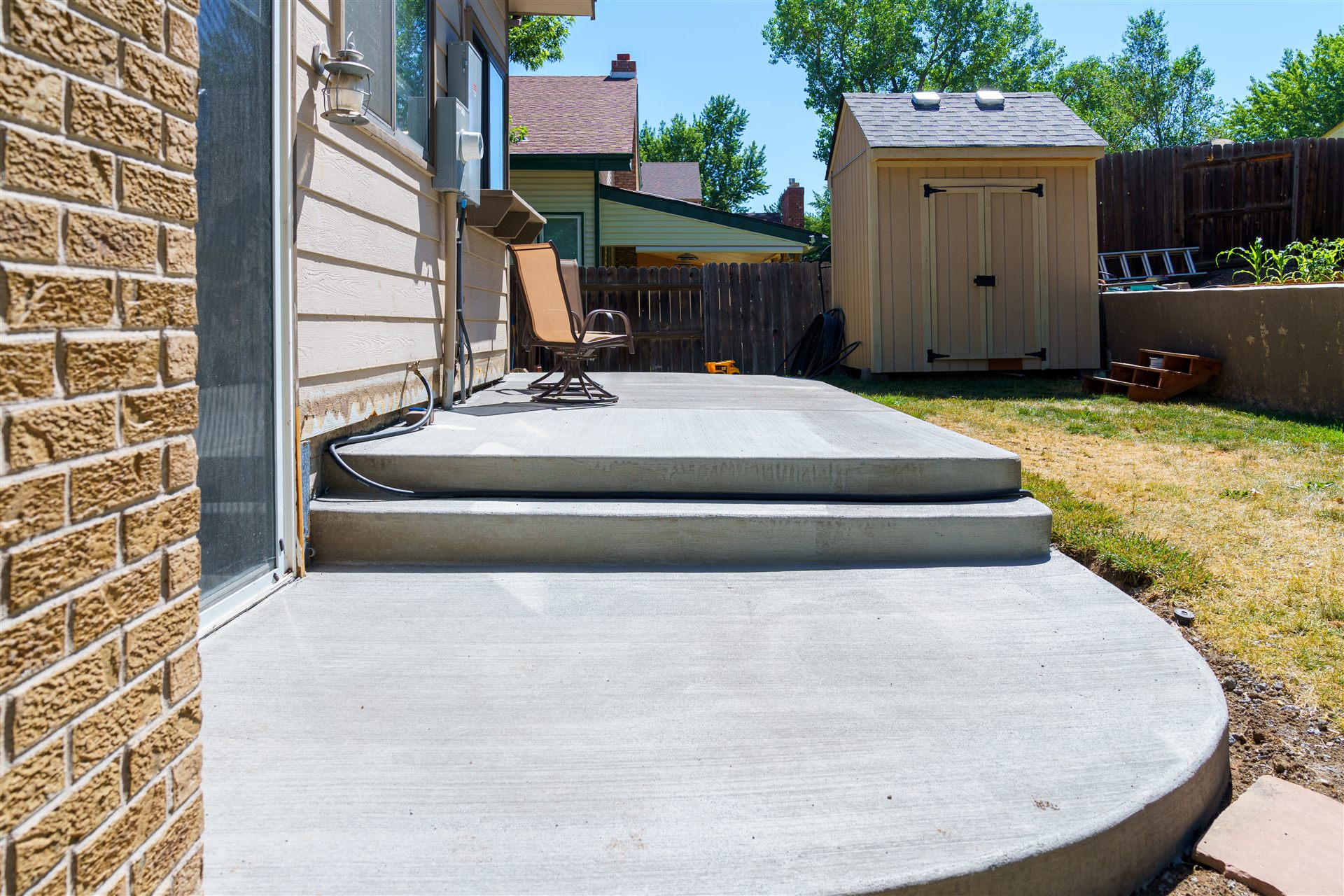 Concrete back patio with wide steps and a rounded landing