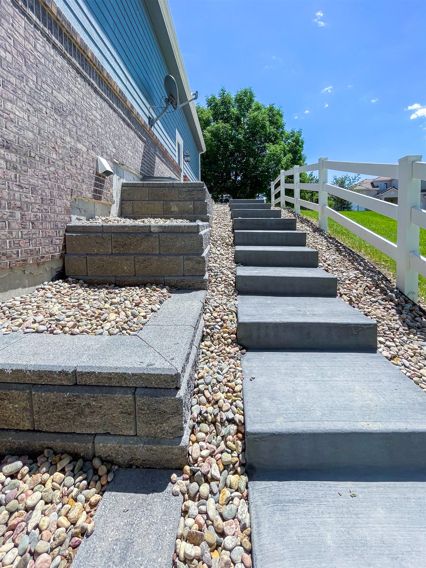 Concrete steps beside stepped block retaining walls and river rock