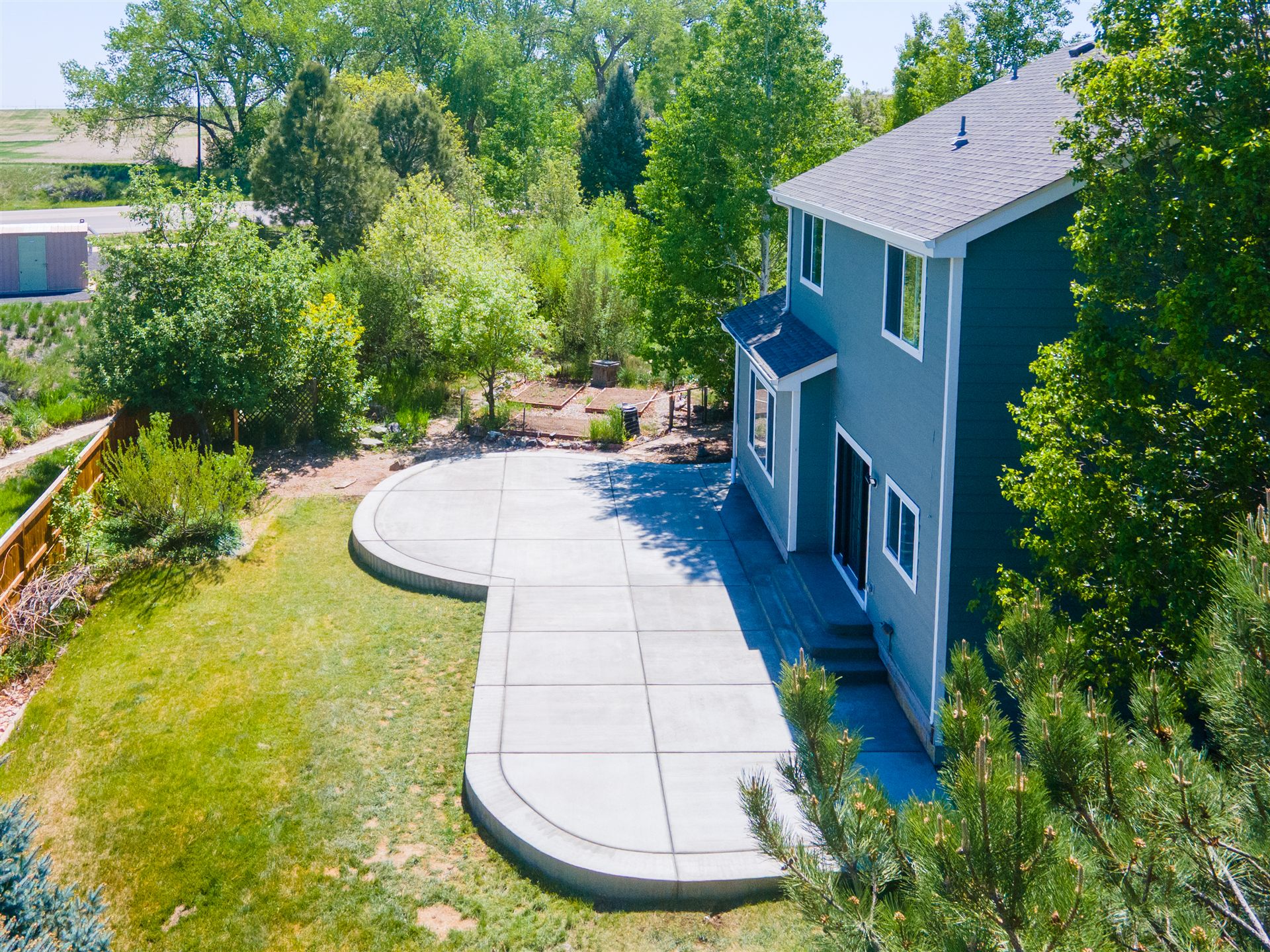Aerial view of a large curved concrete patio behind a home in Westminster, CO