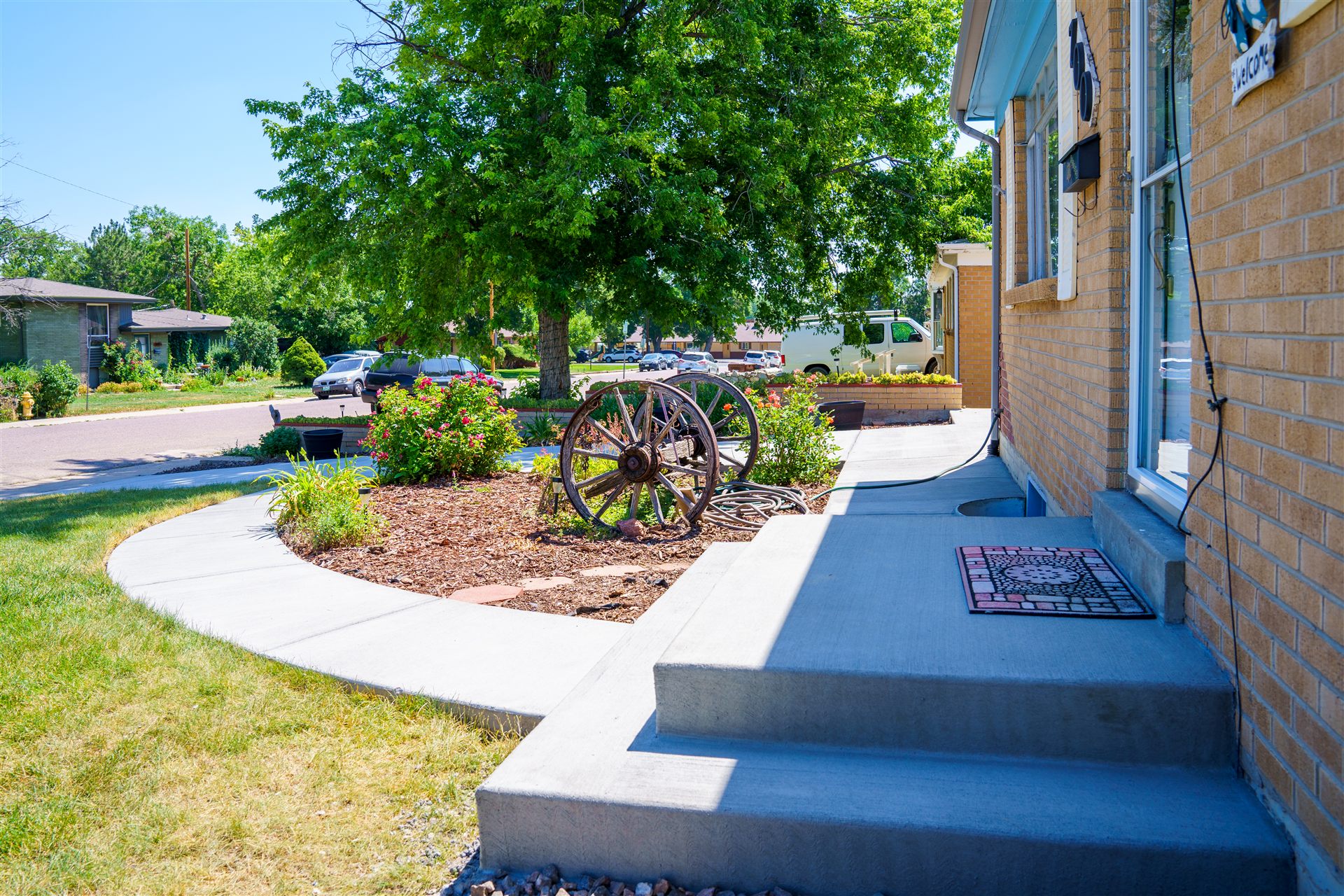 Concrete front steps and a curved walkway at a brick ranch