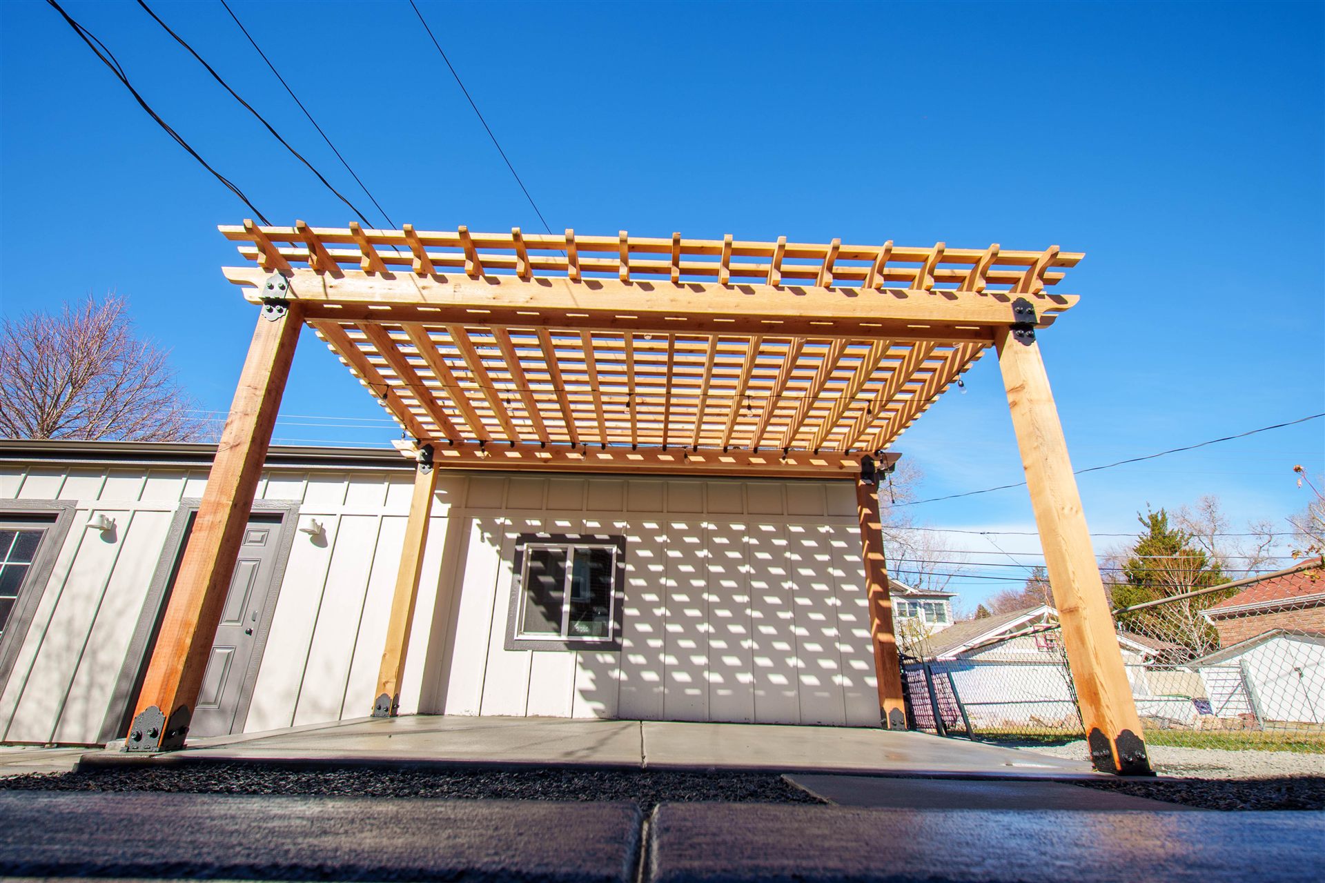 Front view of a wood pergola on steel post bases