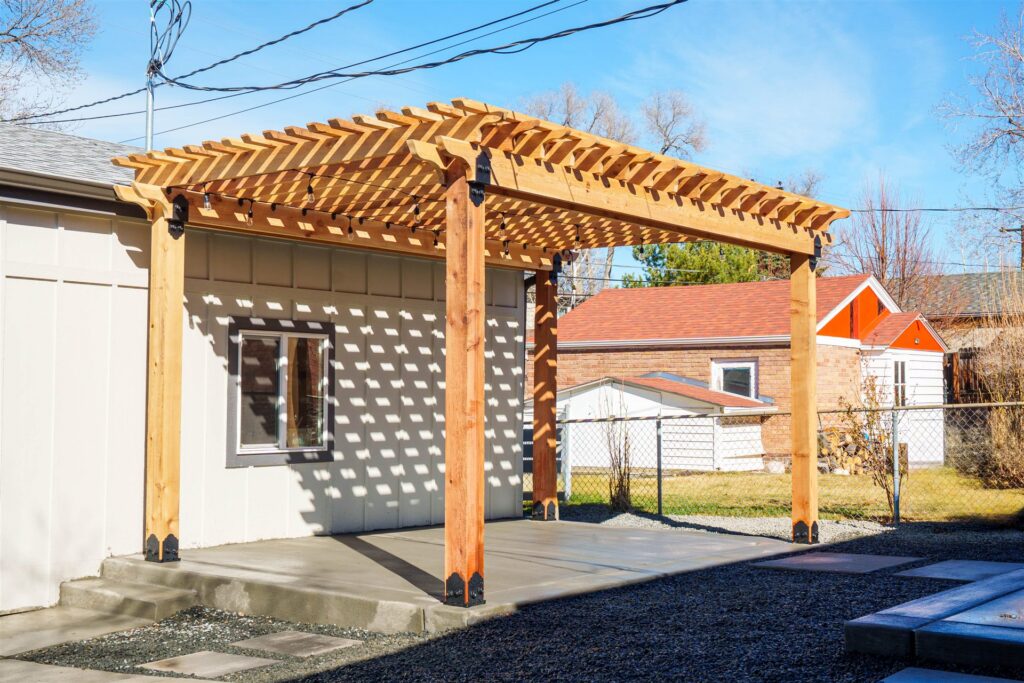 Wood pergola over a concrete patio next to a detached garage in Westminster, CO