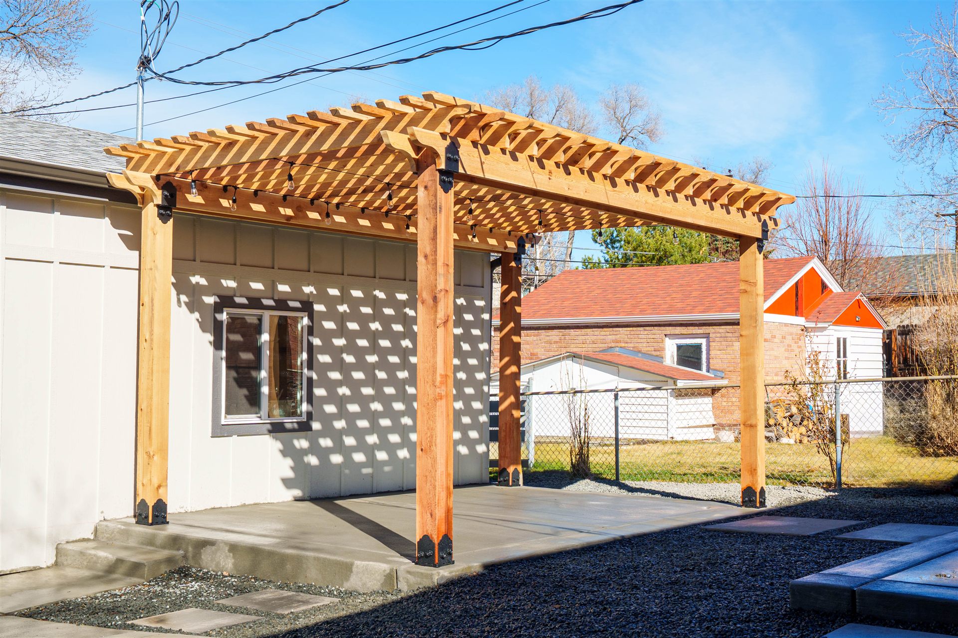 Wood pergola over a concrete patio next to a detached garage in Westminster, CO